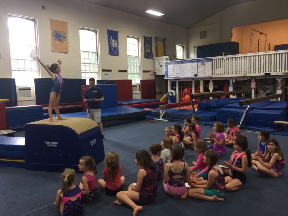 Recreational Gymnasts receiving a medal and certificate of completion at Iron Rail's annual Rec Exhibition
