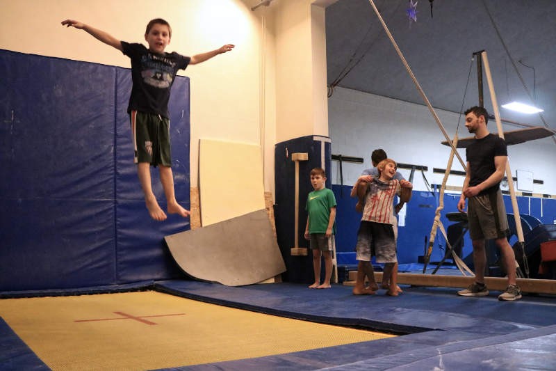 Boys tramp and tumbling class having fun on trampoline